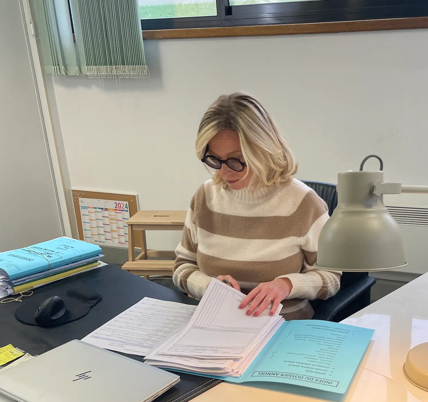 Carole regardant des documents sur son bureau